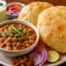 Authentic Punjabi Chole Bhature served hot with spicy chickpea curry, fluffy fried bhature, onions, and lassi.